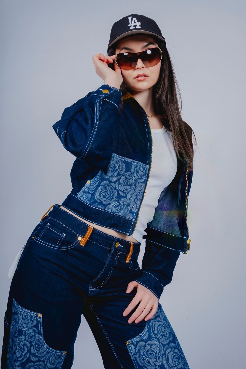 Fashion portrait in patterned denim, sunglasses and a cap