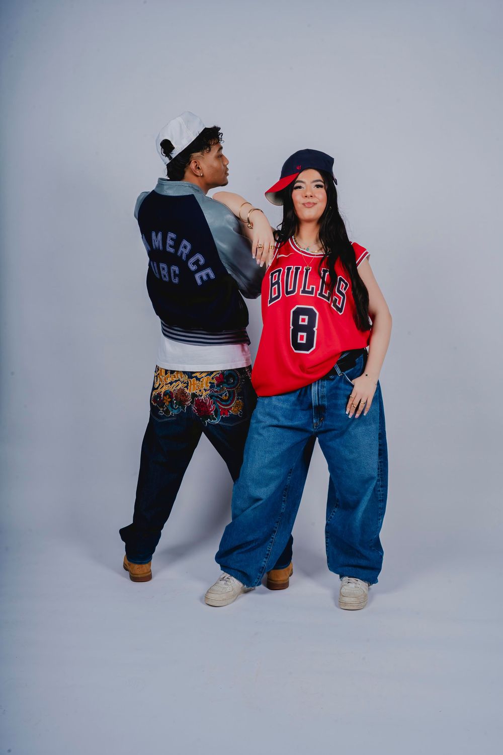 Two models in a varsity jacket and basketball jersey