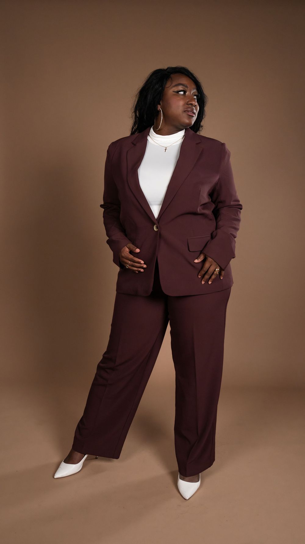 Full-length fashion portrait in a burgundy suit and white shoes