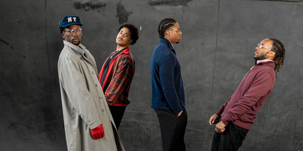 Four models posing against a concrete backdrop