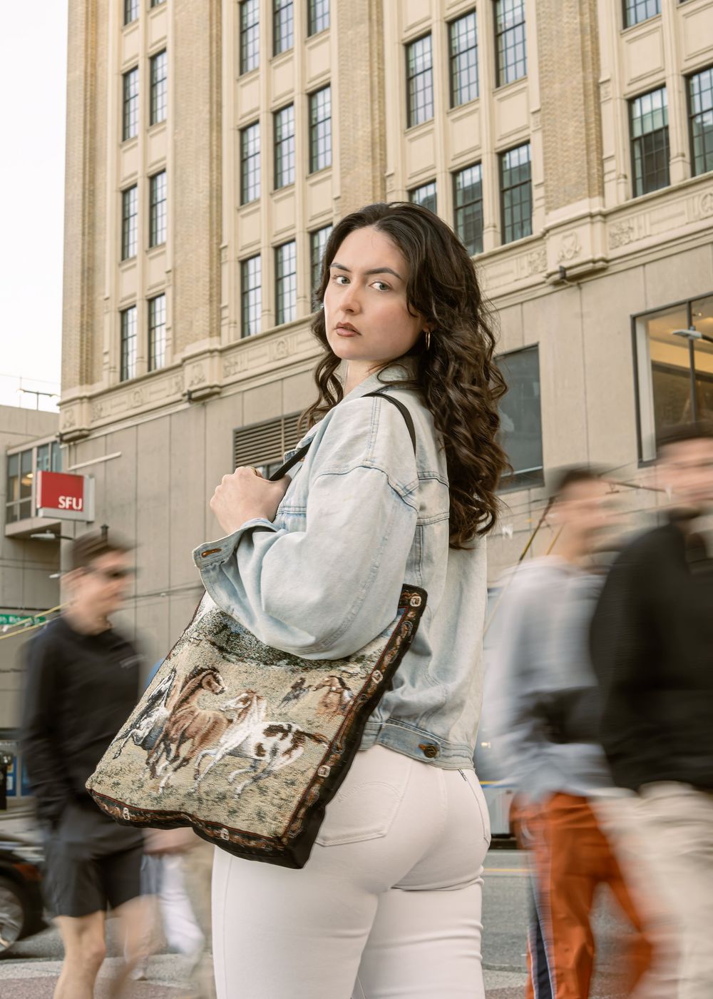 Street portrait with a patterned bag and passing pedestrians