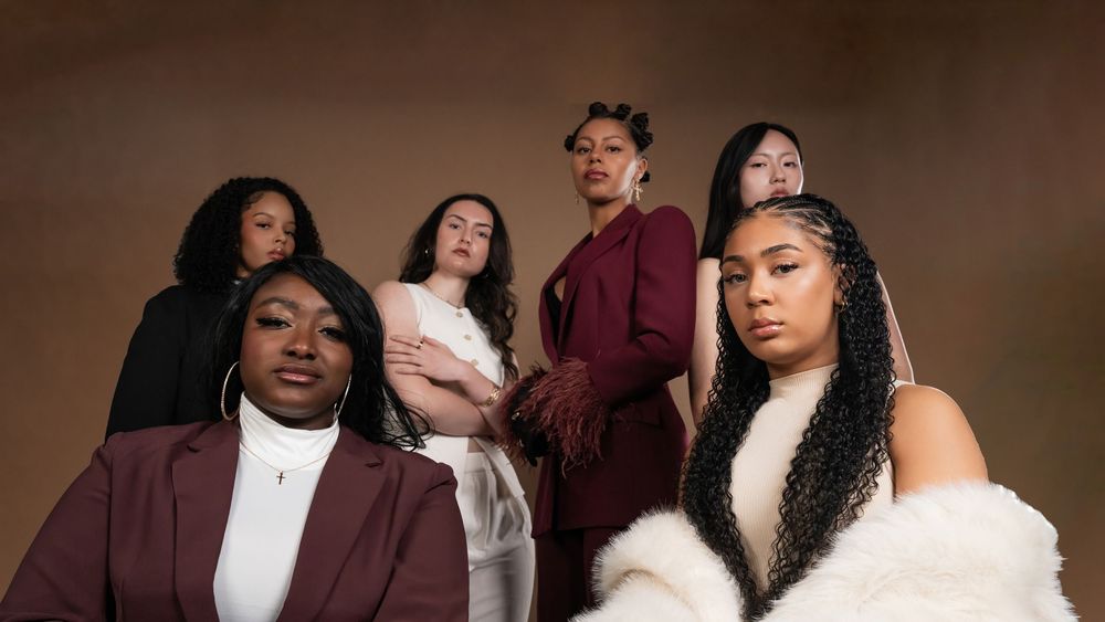 Group fashion portrait in cream and burgundy against a brown studio backdrop