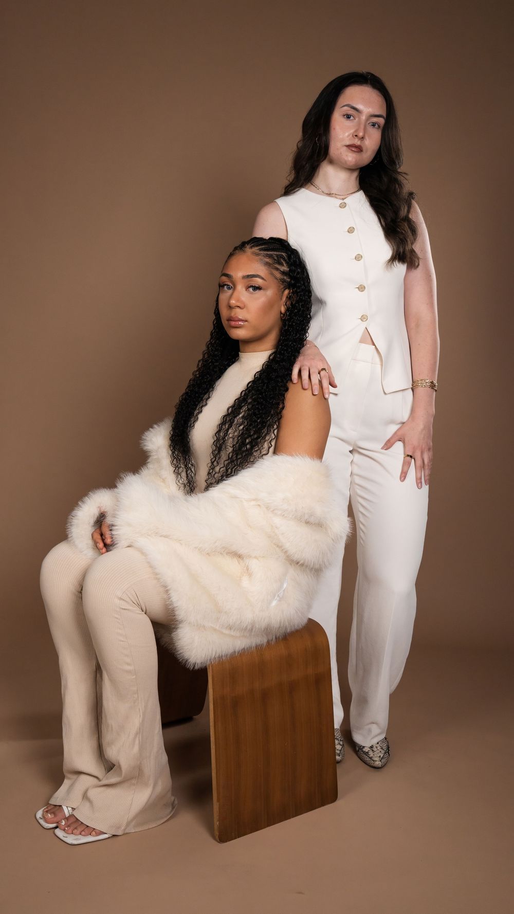 Full-length studio portrait of two models in cream